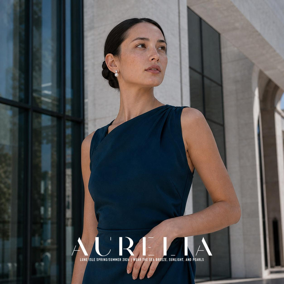 Model in a dark blue one-shoulder outfit outdoors, wearing the same stacked clear-accent and round white-bead stud.