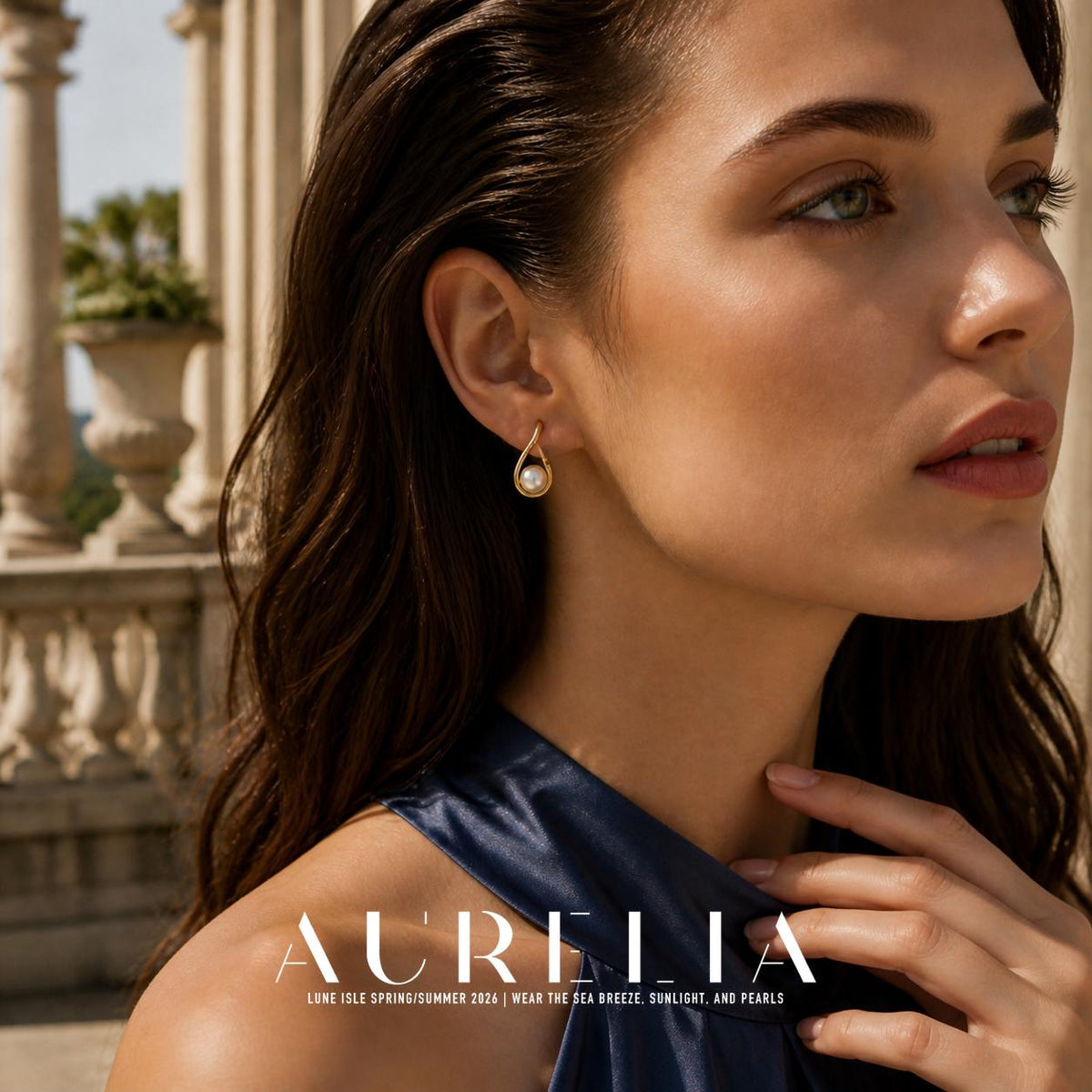Close portrait wearing the gold-tone open teardrop earring with white bead.