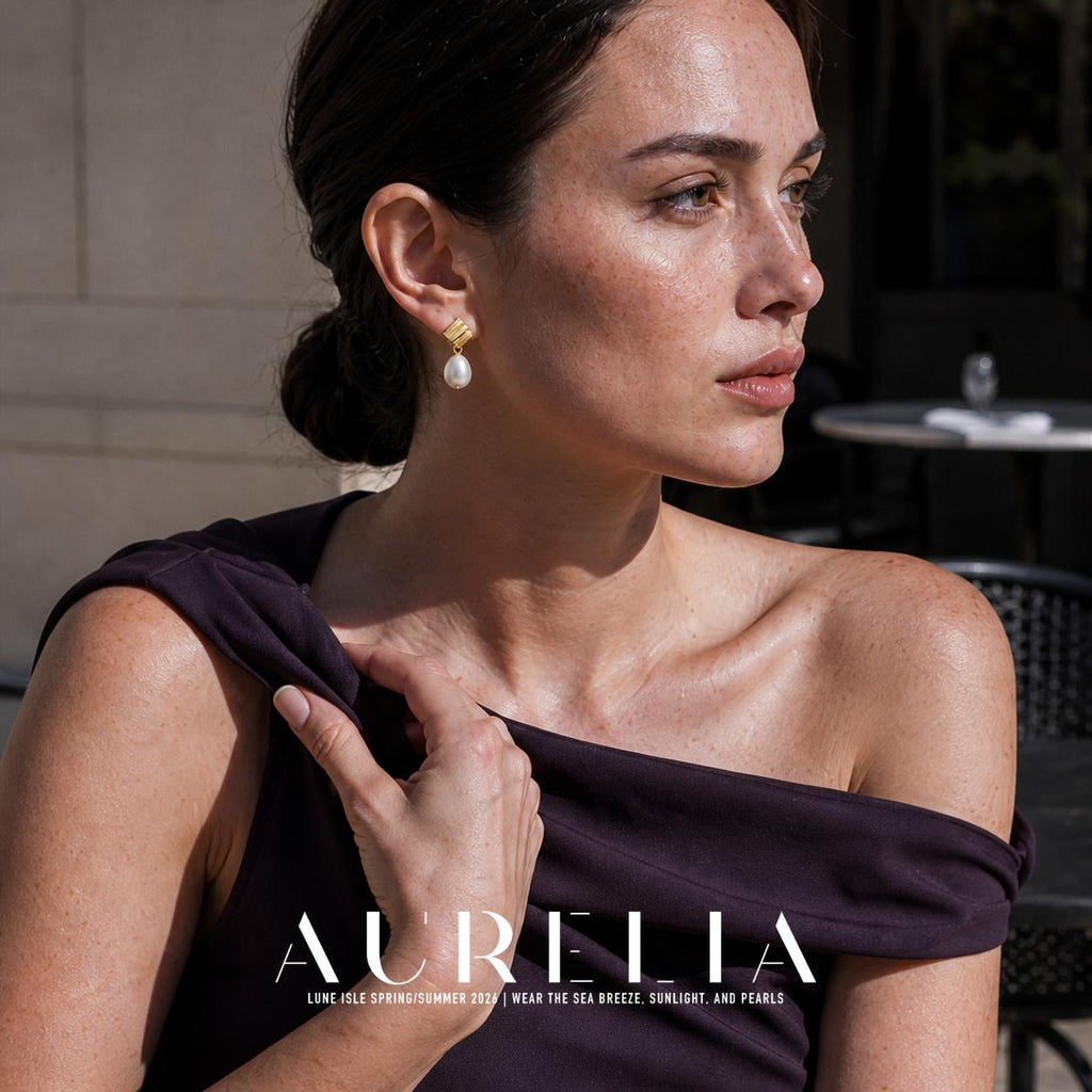 Seated portrait with shoulder visible. Textured folded gold-colored square/rectangular top with one oval white drop and a small joining ring; the same two-part structure appears in all worn views.