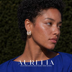 Close portrait of rounded white swirl stud with gold-tone edging and central white bead.