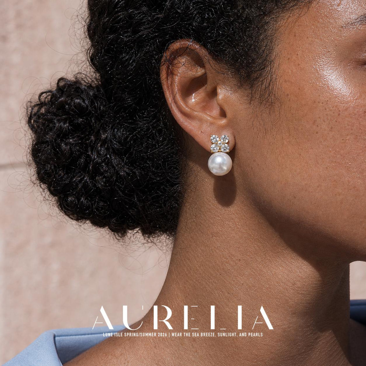 Close view of a four-petal clear-accent cluster above a round white pearl-like bead, with gold-tone details.