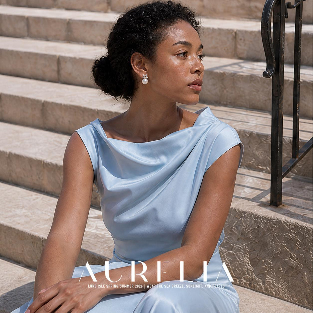 Seated model on stairs wearing clover-cluster and white-bead earrings.