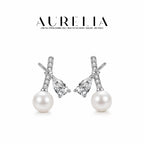 Silver-tone standalone crossed-bar pair with separate pear-shaped clear accents and white round beads.