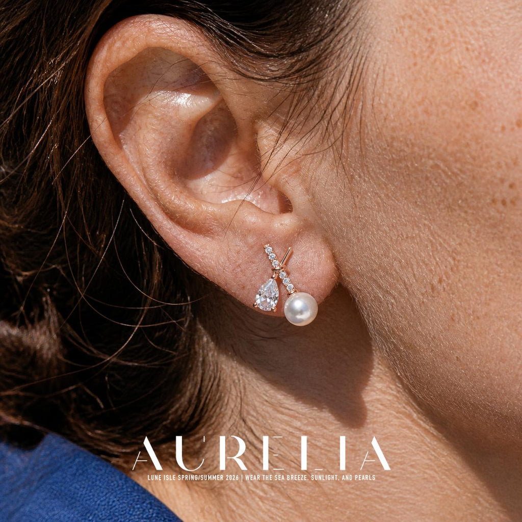 Close ear view of the crossed bars, pear-shaped clear accent and round white bead.