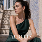 Seated portrait on tiled stairs wearing slender curved drop earrings.