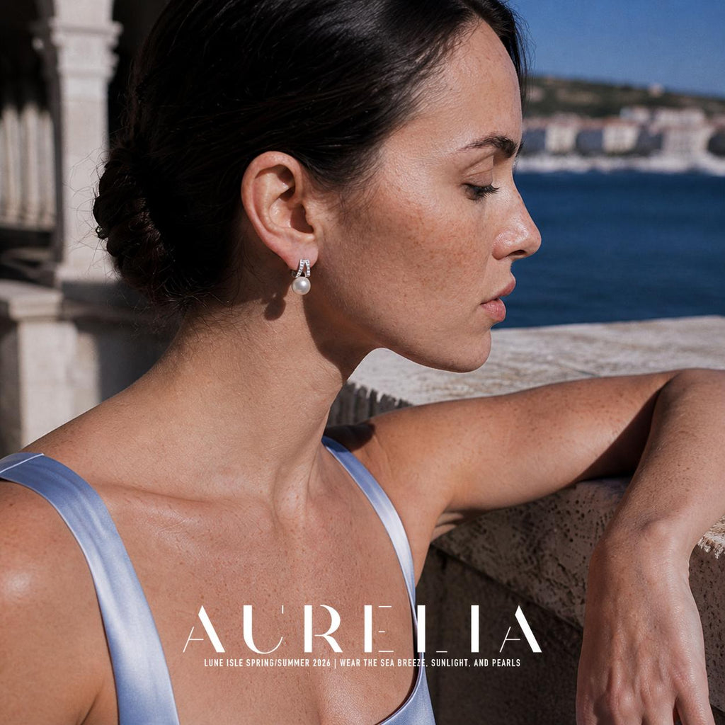 Side-profile model leaning at balustrade wearing paired-bar and white-bead stud.