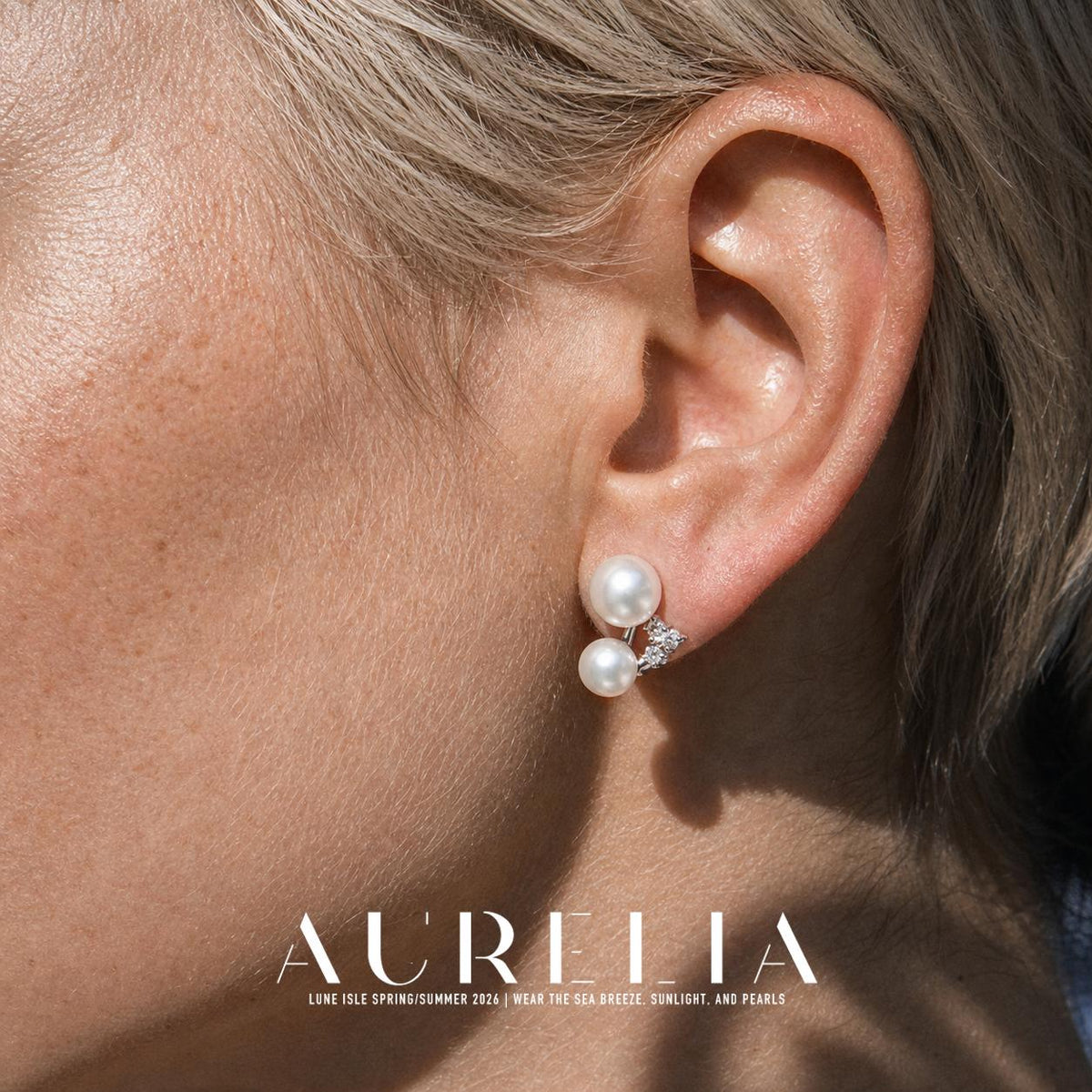 Close view of two unequal white round beads and a small bright accent cluster arranged in an open triangle.