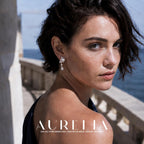 Over-shoulder waterfront portrait showing the same shooting-star earring from another direction.