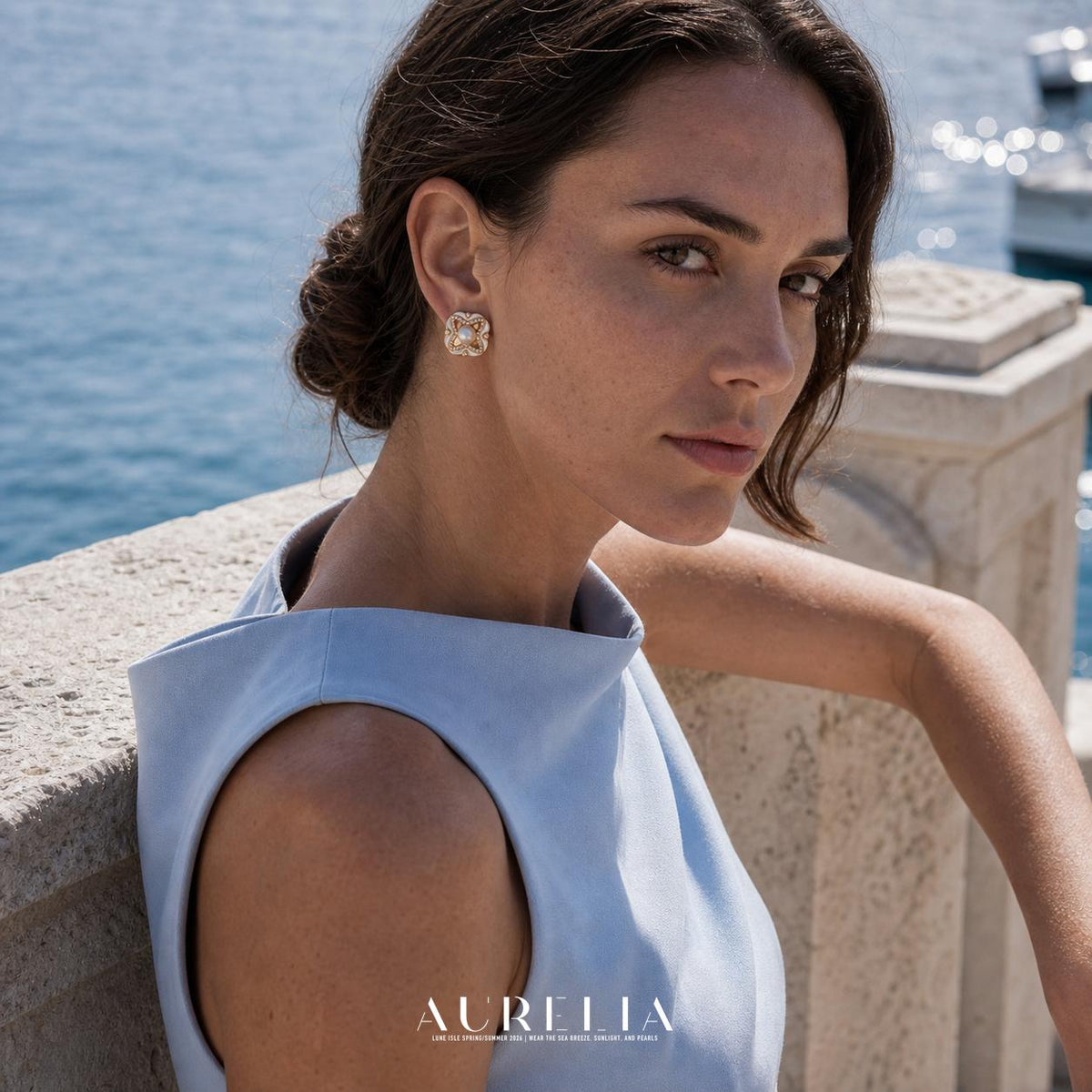 Seated waterfront side portrait in blue, showing the clover stud on the exposed ear.