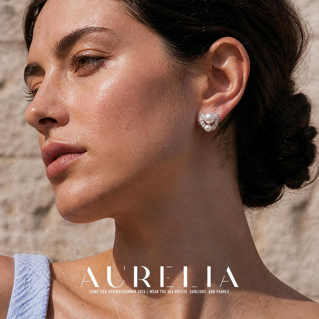 Close ear portrait of silver-colored clear-accent curved stud with one large and one smaller white bead.