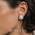 Close ear view showing the divided white triangular face and central round bead.