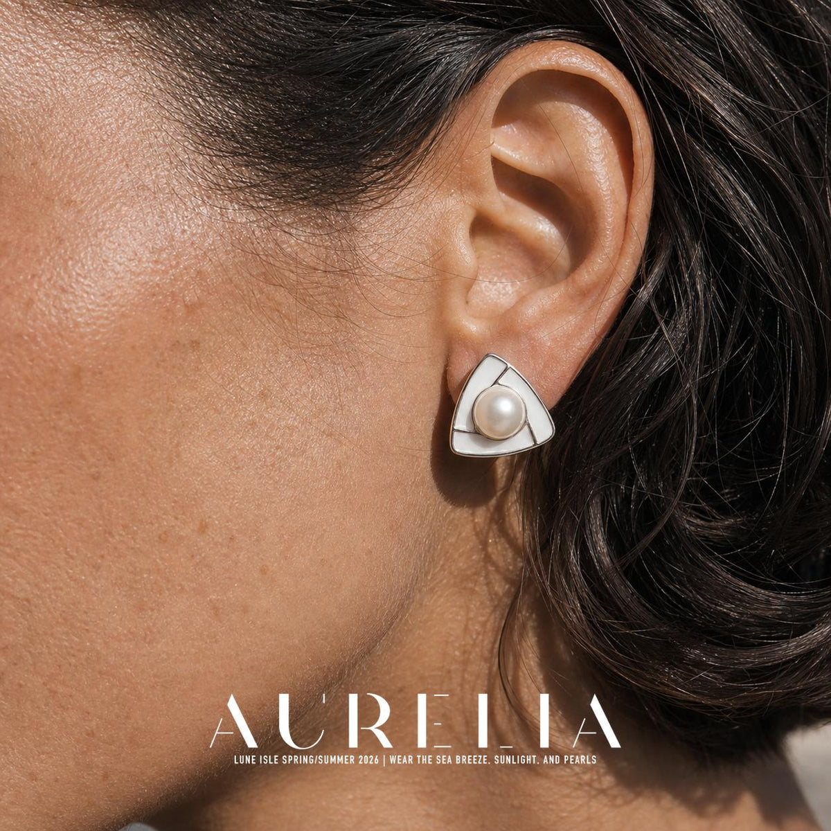 Close ear view showing the divided white triangular face and central round bead.