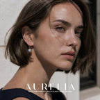 Head-and-shoulders portrait in a dark sleeveless dress, with the gray bead and curved hook visible.