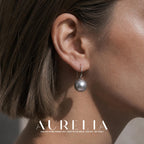 Close side view of a plain curved hook supporting a single gray round bead.