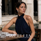 Seated model wearing open horseshoe clear-accent tops with white round drops.