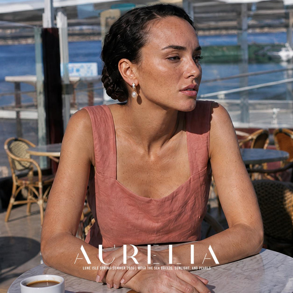 Model in a rose dress at a cafe table, wearing the same short inset-band-and-drop earring.