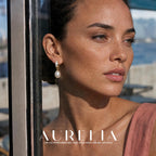 Close portrait beside a window clearly showing matching pale inset hoop, small connector rings and oval white drop.