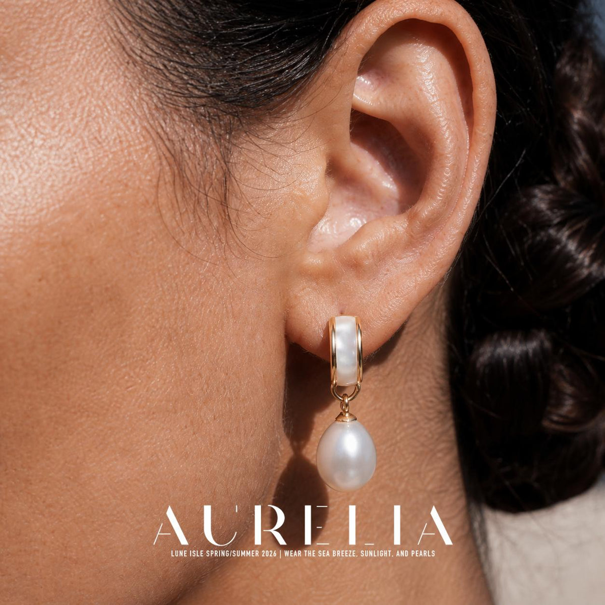 Ear close-up showing the pale inset band, gold-colored edges and white oval drop.