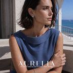 Seaside portrait in a blue dress showing the circular stud worn.