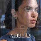 Portrait through glass; reflections do not obscure the twisted open circular border and lower round accent.