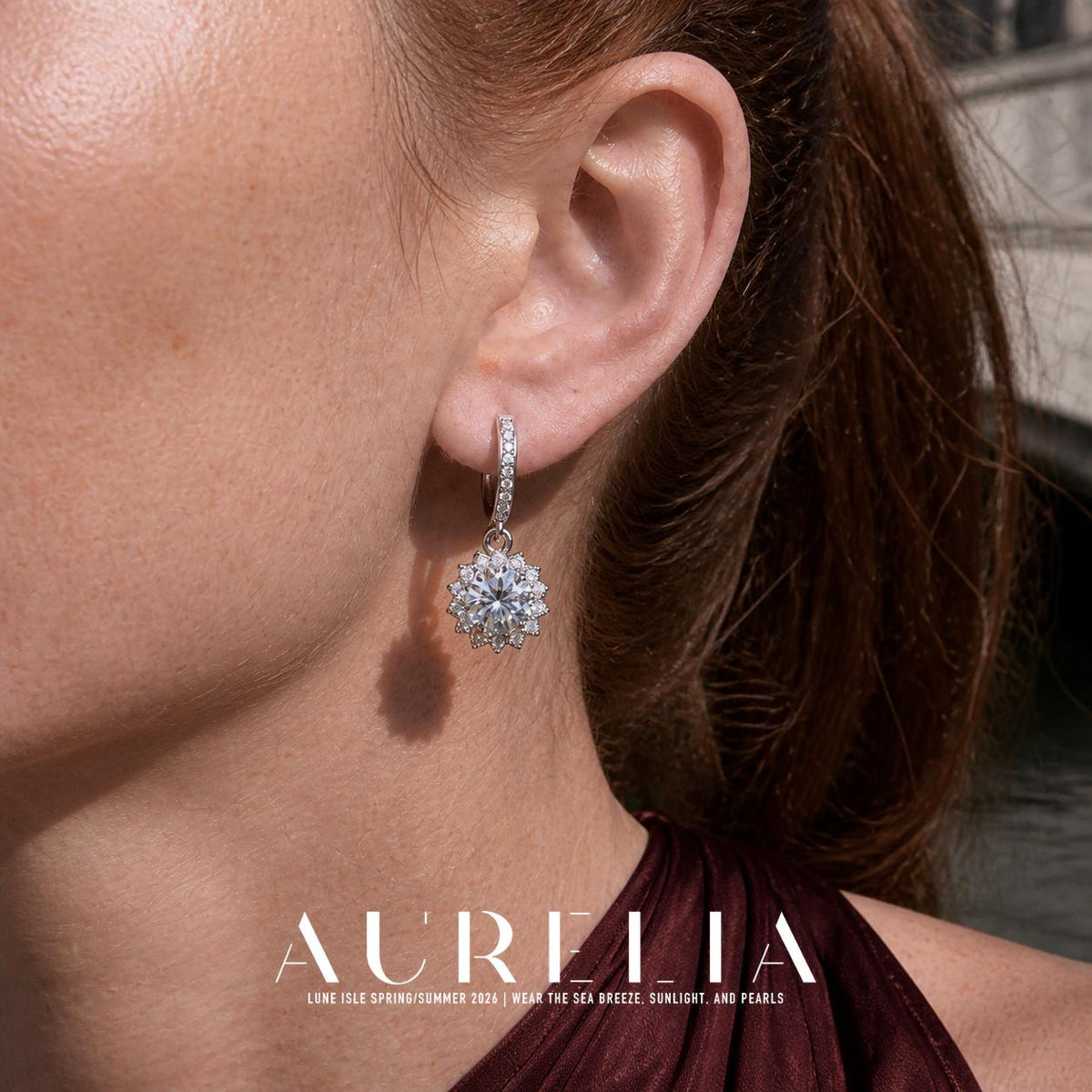 Close ear view showing the hoop and dangling sunflower-shaped clear-stone motif.