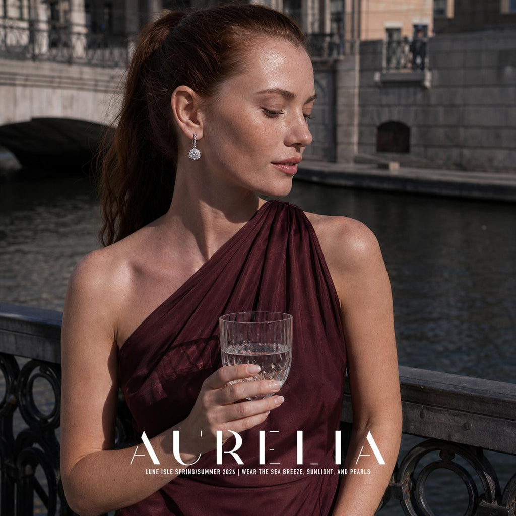 Canal-side portrait holding a glass shows the slim clear-set hoop, connector and sunflower-shaped drop.