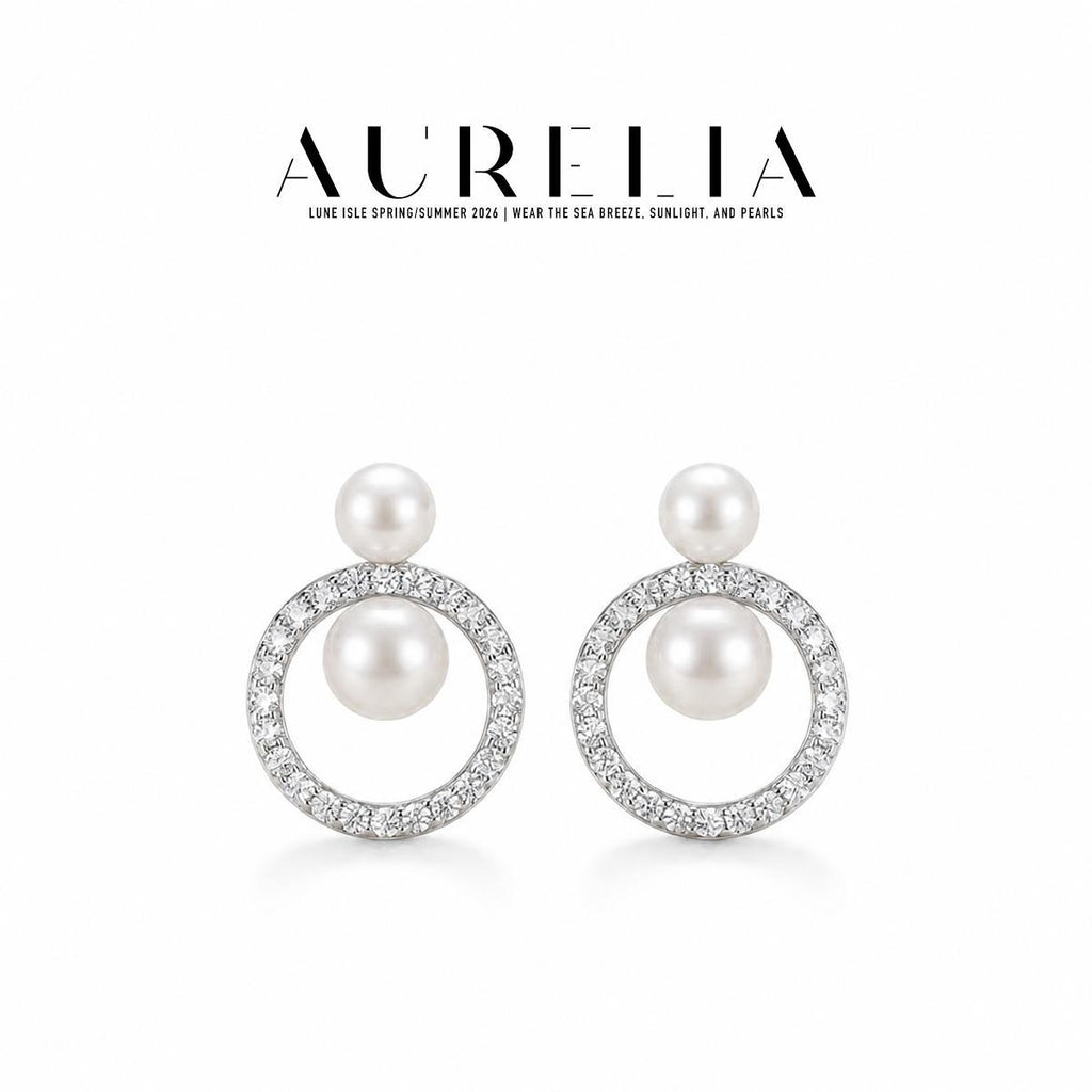 Clean studio pair in silver tone: small upper white bead and larger bead suspended inside a clear-stone circular frame.