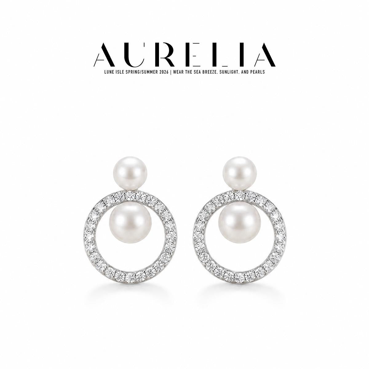 Clean studio pair in silver tone: small upper white bead and larger bead suspended inside a clear-stone circular frame.