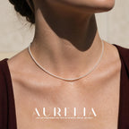 Close neck view of a continuous single strand of small, round, pale beads.