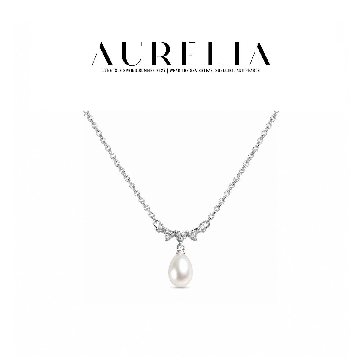 Clean silver-tone necklace still with shallow clear-stone wave and single white teardrop bead.