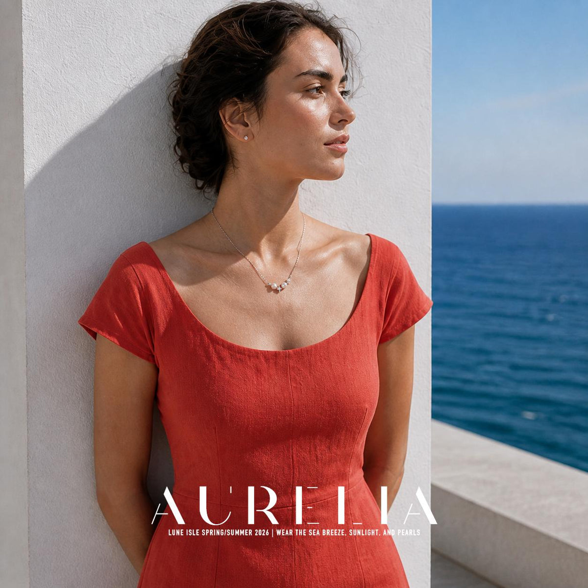 Waist-up seaside portrait in red, silver-tone necklace visible against skin.