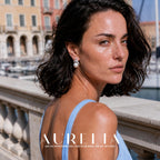Over-shoulder marina portrait in blue, showing curled silver-tone ribbons above white bead.