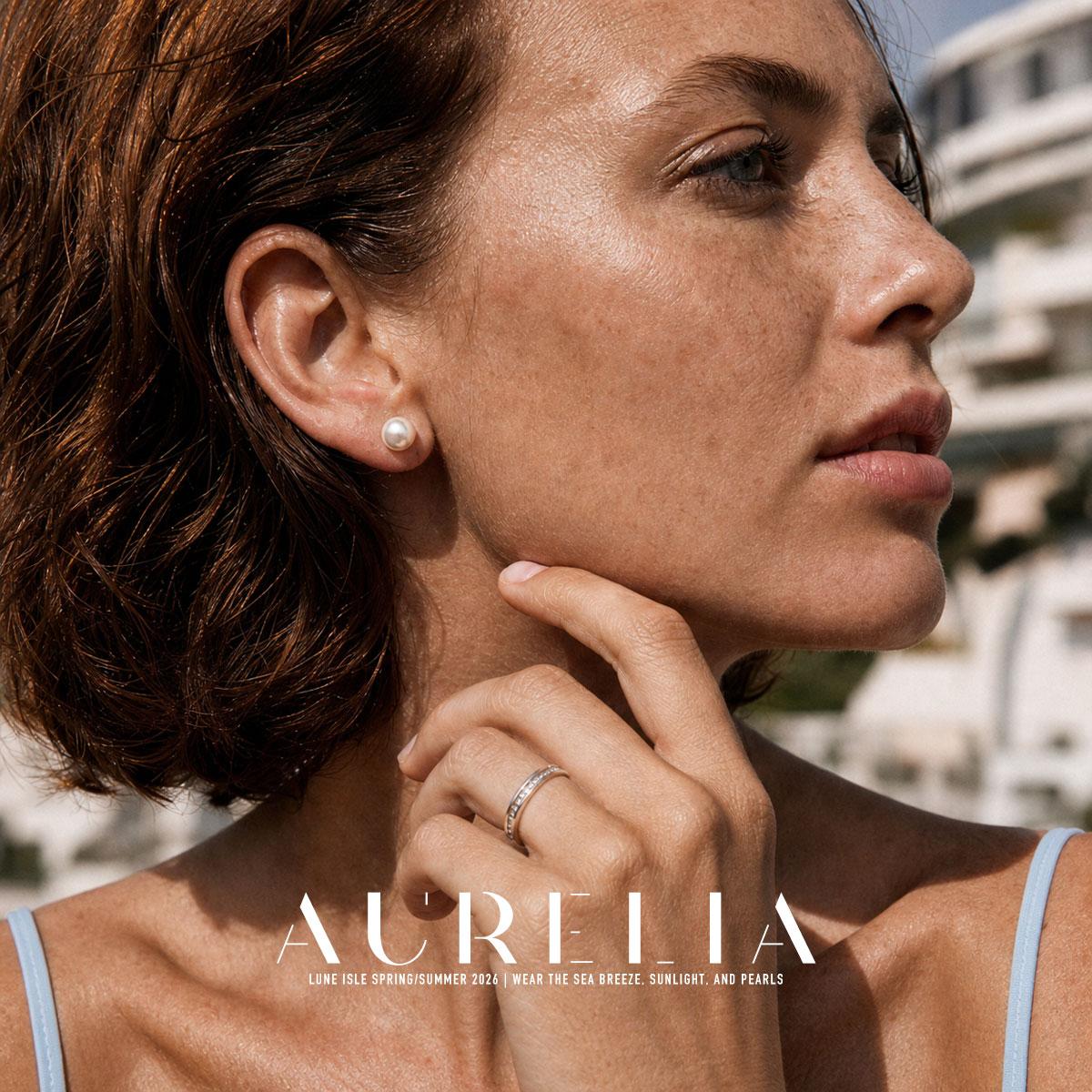 Close portrait with hand at chin showing the matching simple white round stud.