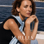 Seated boat portrait wearing a simple smooth white round stud; bracelet is incidental.