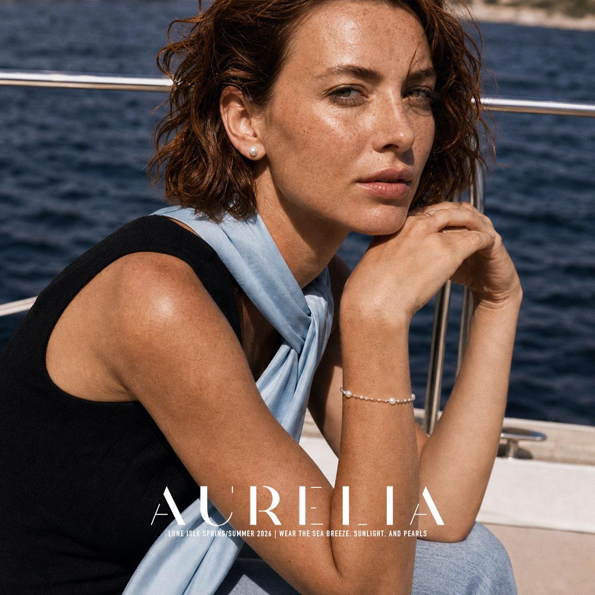Seated boat portrait wearing a simple smooth white round stud; bracelet is incidental.