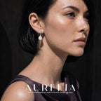 Close portrait showing the clear stud, ring connector and white drop against dark hair.