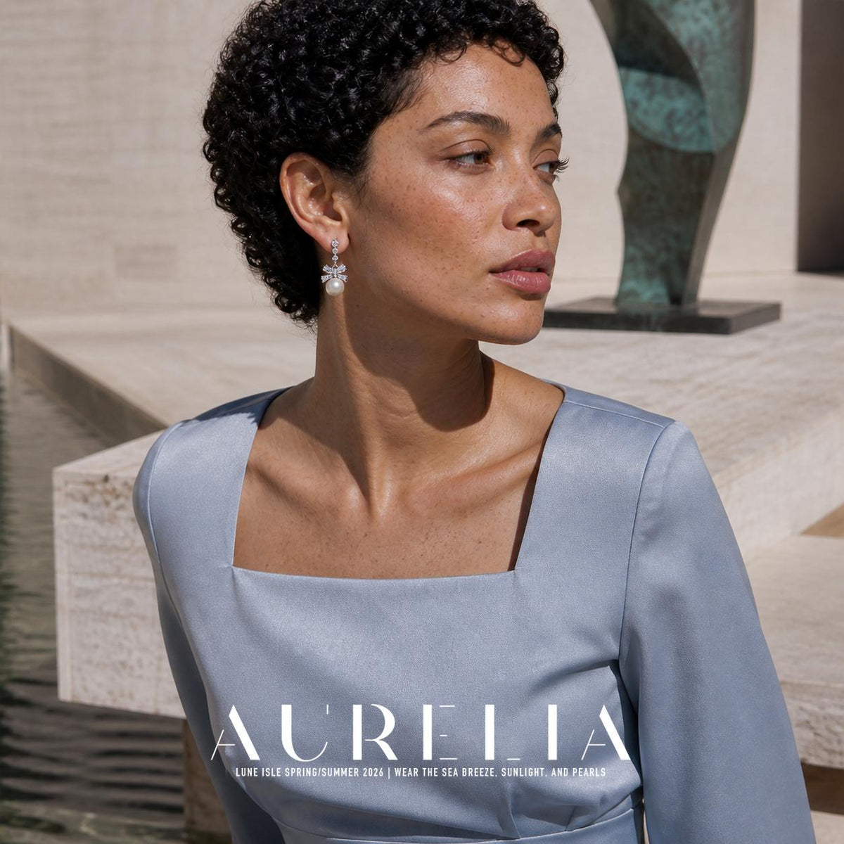 Model in pale blue wearing three upper accents, a bow and round white drop.