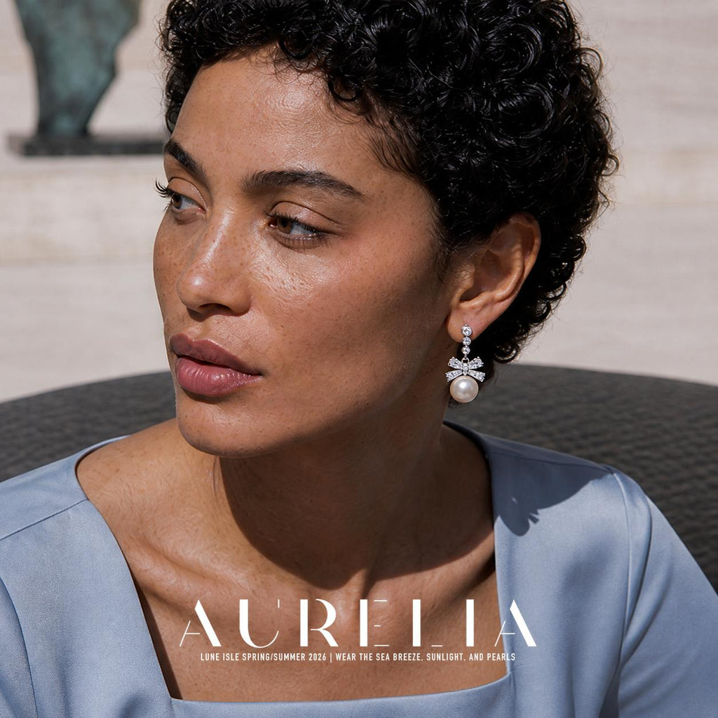 Close angled portrait wearing clear-accent bow and white round drop.