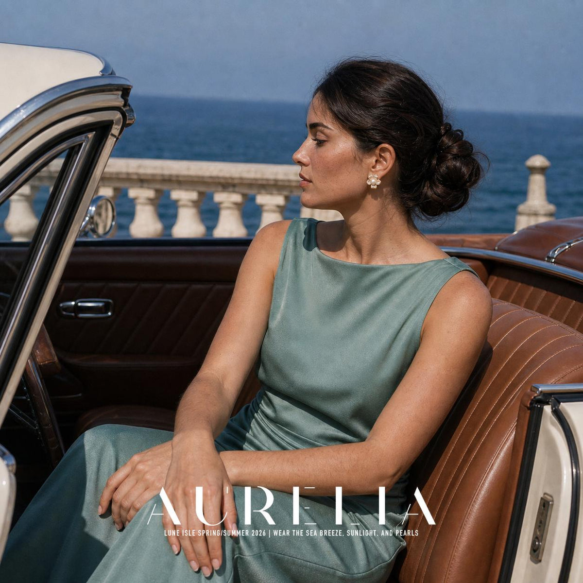 Model in a green dress seated in a car by the waterfront with the flower stud visible.