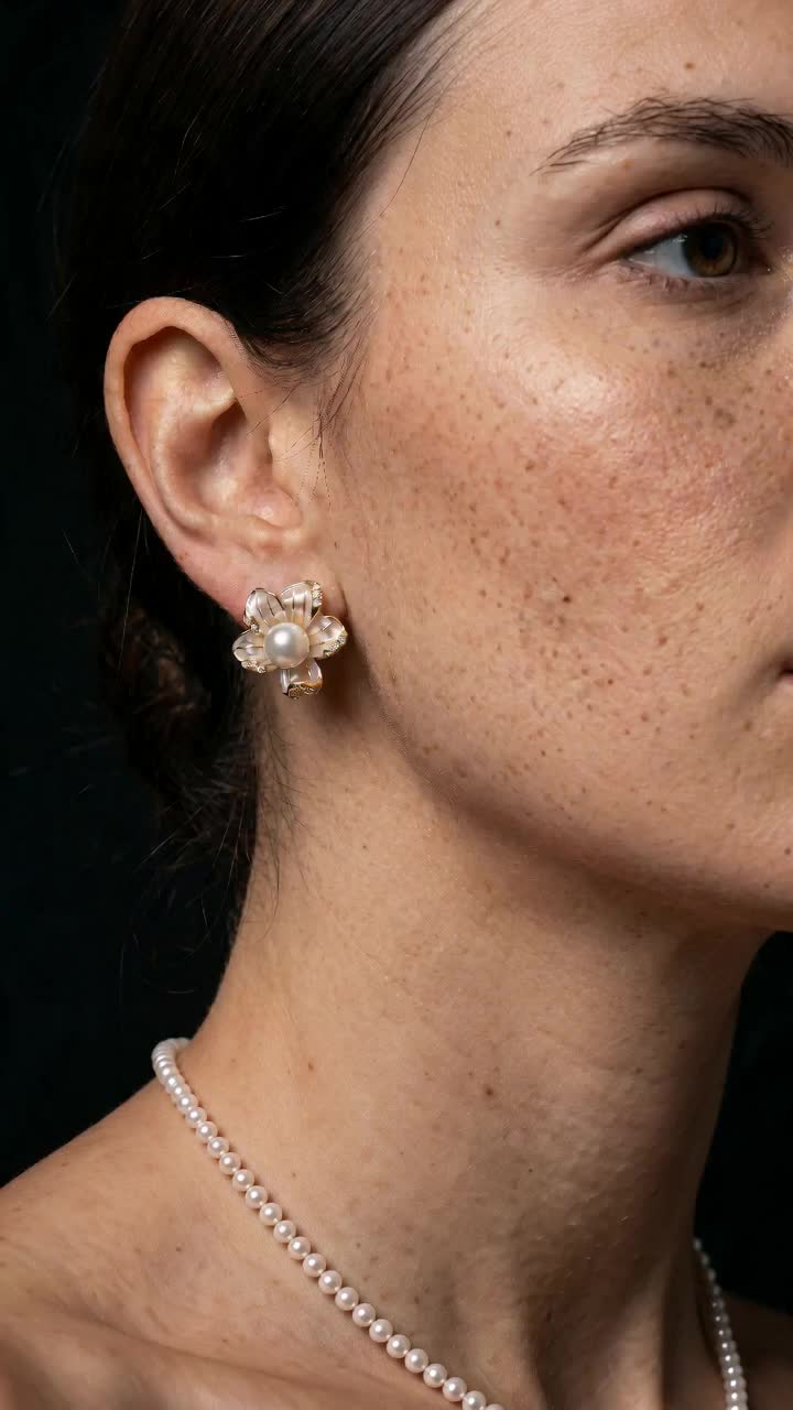 Vertical ear portrait clearly showing the matching five-petal stud; incidental strand necklace is visible.