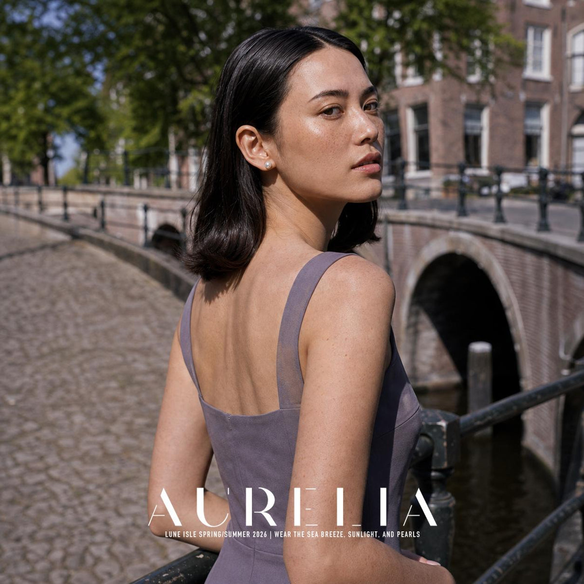Over-shoulder canal portrait in a mauve dress with the matching simple round stud visible.