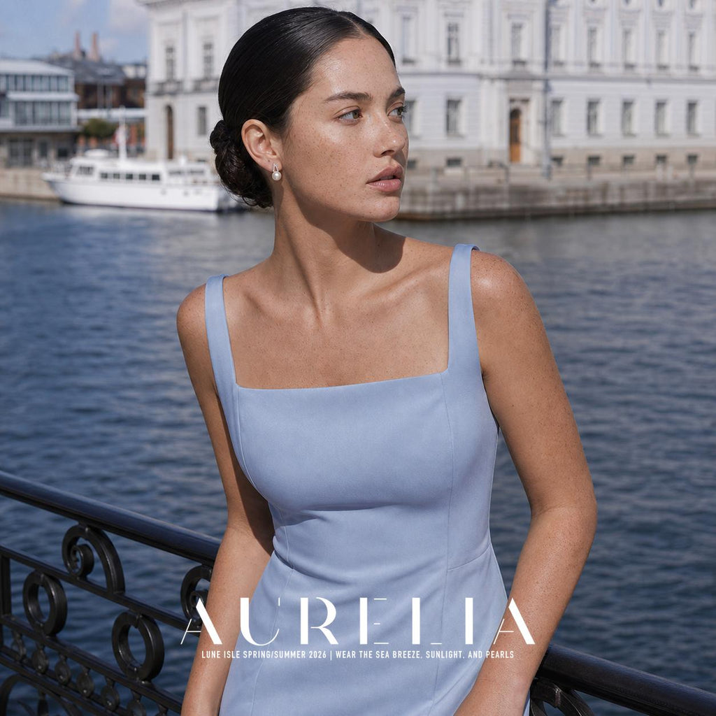 Wider waterfront portrait in a blue dress with matching twin-arc earring visible.