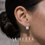 Close ear view showing the two stone-lined arcs and round white bead.