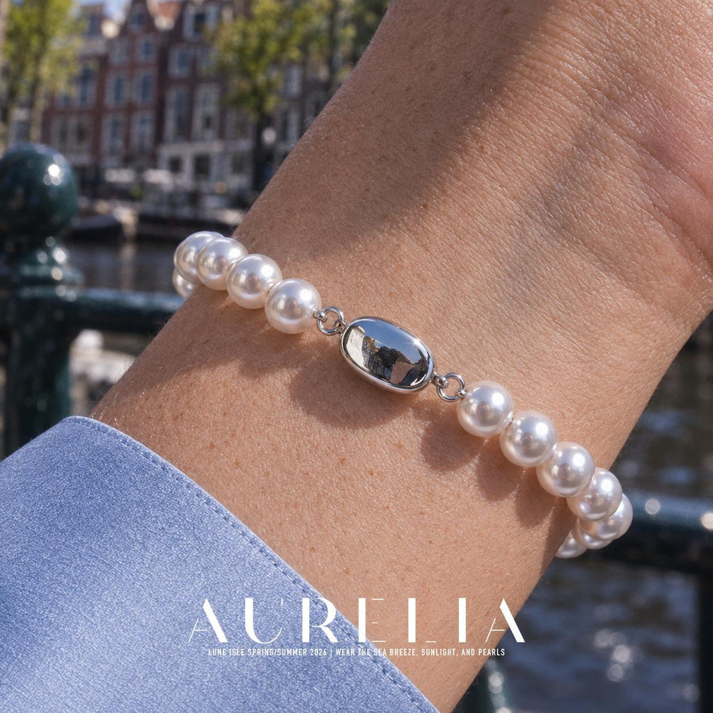 Close wrist view showing the oval clasp. Single row of white round beads with a smooth oval silver-colored clasp; the close clasp view matches the main, and other worn views show the same plain strand. No worn photo is assigned to an exclusive size variant.